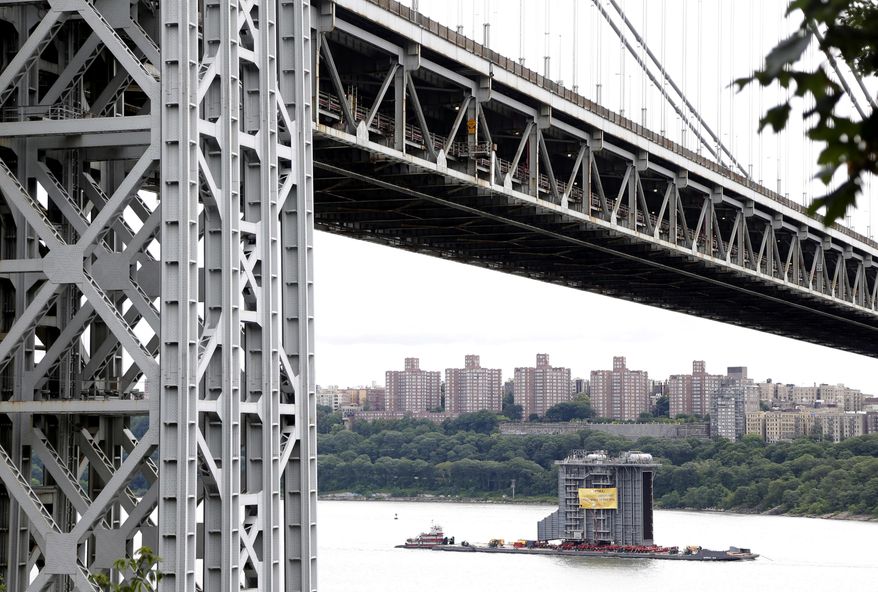 A large generator passes under the George Washington Bridge as seen from Fort Lee, N.J., Tuesday, Aug. 8, 2017. The 130-foot-(40-meter)-tall steam generator built along the Hudson River outside Albany is on a barge heading south for a New Jersey power plant. (AP Photo/Seth Wenig)