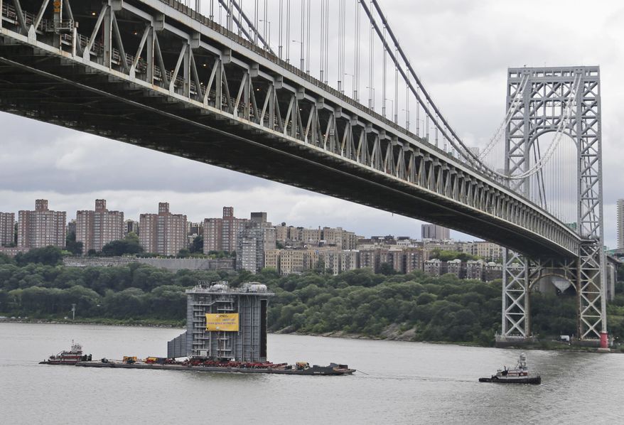 A large generator passes under the George Washington Bridge as seen from Fort Lee, N.J., Tuesday, Aug. 8, 2017. The 130-foot-(40-meter)-tall steam generator built along the Hudson River outside Albany is on a barge heading south for a New Jersey power plant. (AP Photo/Seth Wenig)