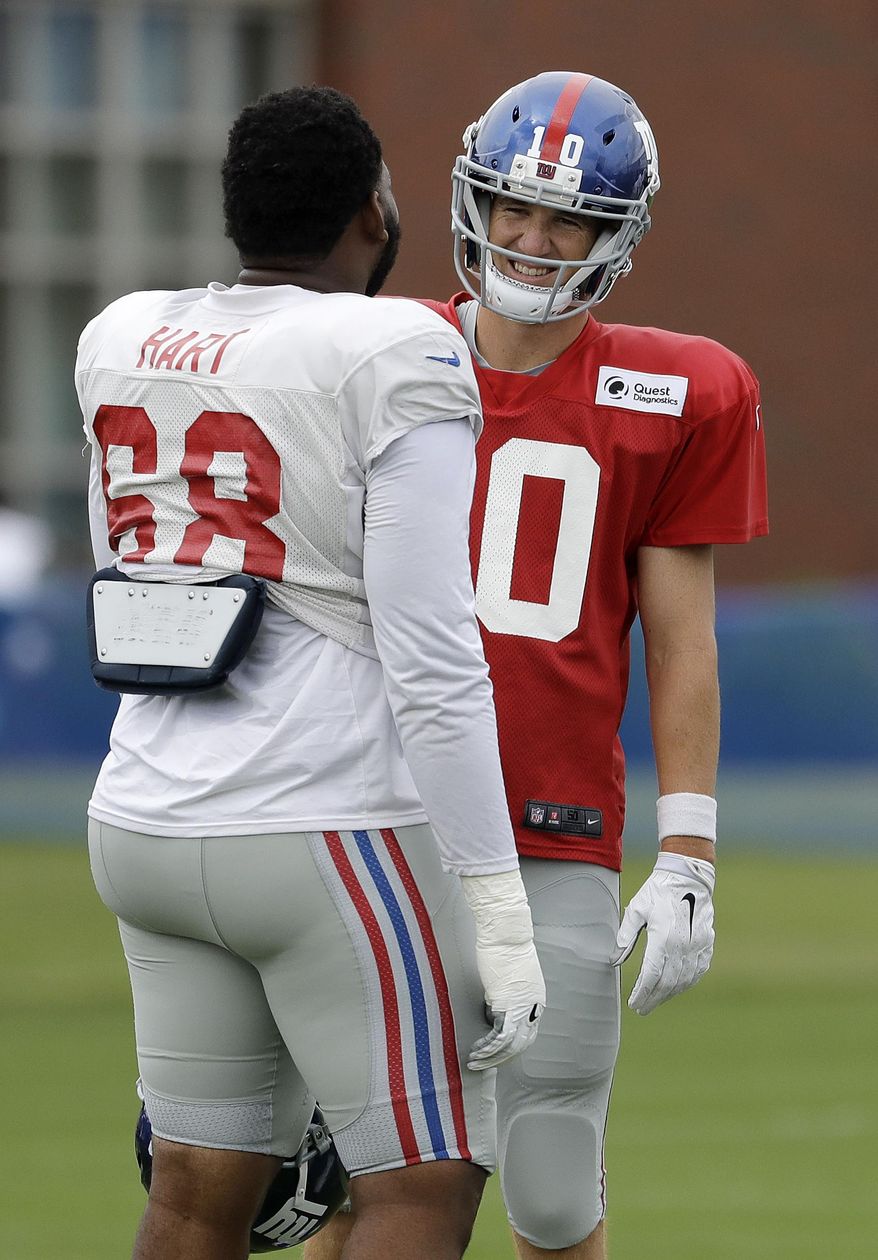 New York Giants offensive tackle Bobby Hart, left, talks to quarterback Eli Manning during NFL football training camp, Tuesday, Aug. 8, 2017, in East Rutherford, N.J. (AP Photo/Julio Cortez)