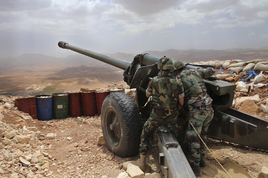 FILE -- In this June 19, 2016 file photo, Lebanese army soldiers work on a 130mm howitzer cannon, pointed at areas controlled by Islamic State group militants near Arsal, in northeast Lebanon. Lebanon’s U.S.-backed military is gearing up for a long awaited assault to dislodge hundreds of IS militants from a remote corner of northeastern Lebanon near the border with Syria, seeking to end a years-long threat posed to neighboring towns and villages by the extremists. (AP Photo/Hussein Malla, File)
