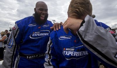 Washington Redskins linebacker Will Compton, front, shares a laugh with offensive tackle Morgan Moses, back, after Compton was driven around the track by Dale Earnhardt Jr. Tuesday Aug. 8, 2017 in Richmond, Va. (Shaban Athuman/Richmond Times-Dispatch via AP)