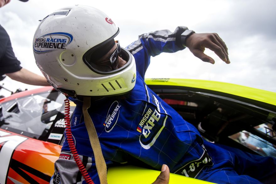 Washington Redskins cornerback Josh Norman squeezes out of Dale Earnhardt Jr.'s car after being driven around the track, Tuesday Aug. 8, 2017 in Richmond, Va. (Shaban Athuman/Richmond Times-Dispatch via AP)