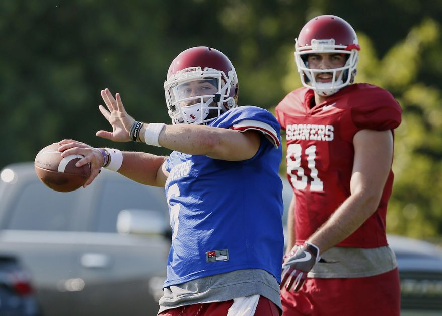 FILE In this Aug. 3, 2017, file photo, Oklahoma quarterback Baker Mayfield, left, throws in front of tight end Mark Andrews (81) during an NCAA college football practice in Norman, Okla. Oklahoma, with Heisman Trophy finalist quarterback Mayfield back for his senior season, will be going for its third consecutive Big 12 title, and 11th overall. (AP Photo/Sue Ogrocki, File)