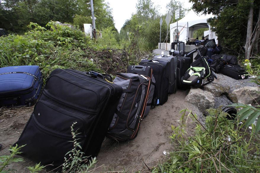 Luggage from migrants fills a pathway at an illegally crossing point from Champlain, N.Y., to Saint-Bernard-de-Lacolle, Quebec, Monday, Aug. 7, 2017. Officials on both sides of the border first began to notice last fall, around the time of the U.S. presidential election, that more people were crossing at Roxham Road. Since then the numbers have continued to climb. (AP Photo/Charles Krupa)