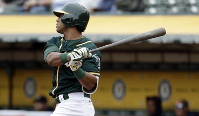 Oakland Athletics&#39; Khris Davis follows through on a solo home run against the Seattle Mariners during the third inning of a baseball game Wednesday, Aug. 9, 2017, in Oakland, Calif. (AP Photo/Marcio Jose Sanchez)