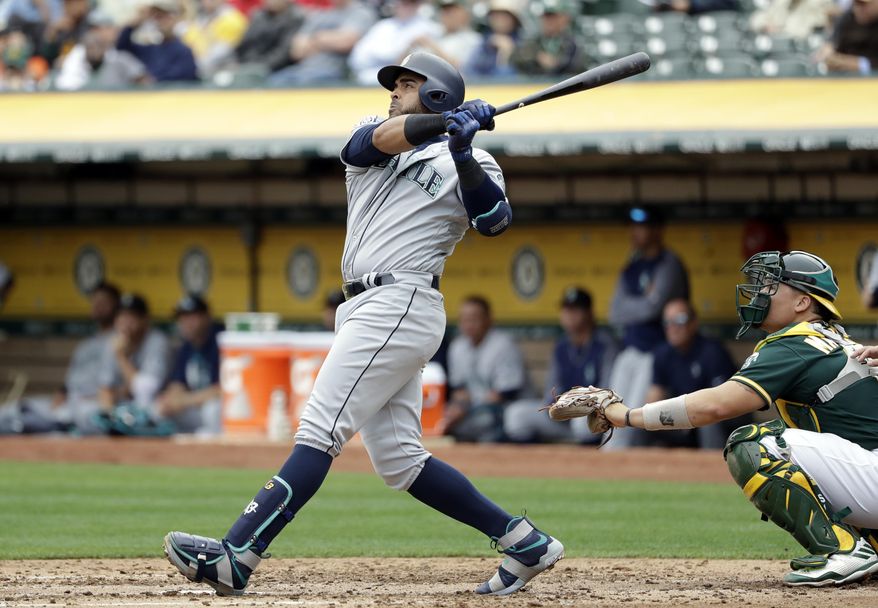 Seattle Mariners&#x27; Nelson Cruz follows through on his two-run home run against the Oakland Athletics during the third inning of a baseball game Wednesday, Aug. 9, 2017, in Oakland, Calif. (AP Photo/Marcio Jose Sanchez)