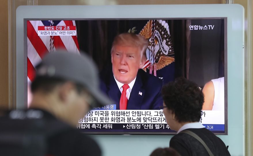 People walk by a TV screen showing a local news program reporting with an image of U.S. President Donald Trump at the Seoul Train Station in Seoul, South Korea, Wednesday, Aug. 9, 2017. North Korea and the United States traded escalating threats, with President Donald Trump threatening Pyongyang &amp;quot;with fire and fury like the world has never seen&amp;quot; and the North&#39;s military claiming Wednesday it was examining its plans for attacking Guam. (AP Photo/Lee Jin-man)