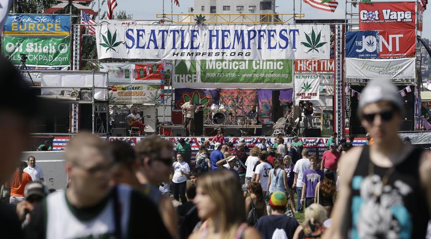 FILE--In this Aug. 16, 2013, file photo, people walk past the main stage at the first day of Hempfest, Friday, Aug. 16, 2013, in Seattle. Seattle on Tuesday, Aug. 8, 2017, agreed to drop a $1,000 fine issued to the nonprofit organization that runs HempFest--the annual summer marijuana celebration. The city accused the organization of operating a marijuana business without a license but later said it had no evidence the group violated the law. (AP Photo/Elaine Thompson, file)