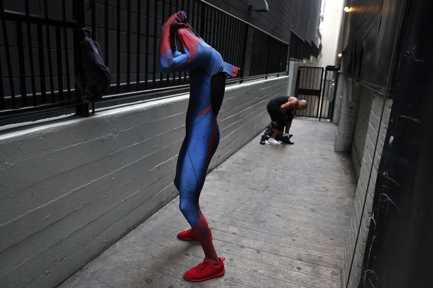 In this Thursday, May 25, 2017 photo, two Spider-Man impersonators, Rashad Rouse, front, and Juan Carlos Banegas, an immigrant from Honduras, change in the alley next to the TCL Chinese Theatre after working on Hollywood Boulevard in Los Angeles. The boulevard is a place of diversity with a cast of superheroes from all over the world including Ukraine, England, Mexico, Germany and Nigeria. (AP Photo/Jae C. Hong)