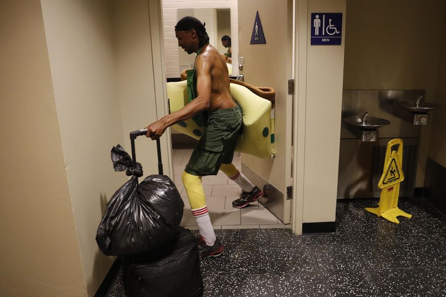 In this Monday, April 17, 2017 photo, covered in sweat, impersonator Belnarr Golden enters a public restroom with his SpongeBob SquarePants costume folded in half after working on Hollywood Boulevard in Los Angeles. While the Hollywood we see in movies is a place of glamour and beautiful celebrities, the cast of superheroes filling Hollywood Boulevard is frequently anything but. Many are people struggling to make a buck as they pursue their dream of stardom. "I crack jokes on them. That's my trick. I make them laugh," said Golden. "If I stand still, I'm not getting paid." (AP Photo/Jae C. Hong)