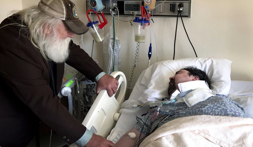 In this April 18, 2017, photo, Walter Wenger visits his severely disabled son, Steven, in a hospital in Kingston, N.Y, where he was moved after maggots were twice found in the area around his breathing tube while living in a state group home. The Associated Press obtained a confidential report on the state investigation that determined the 2016 infestations at the group home in Rome, N.Y., were the result of neglect by caregivers. In most states, details of abuse and neglect investigations in state-regulated institutions for the disabled are almost never made public. (AP Photo/David Klepper)