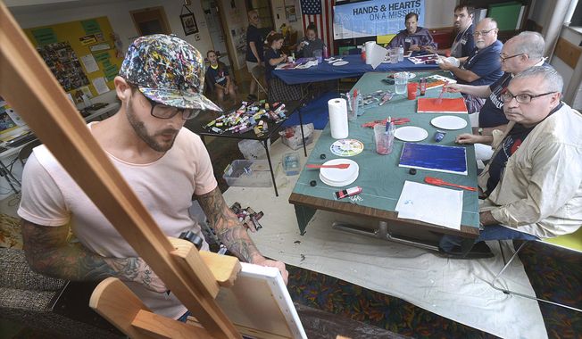 In this July 9, 2017 photo, Jeremy Johnson, bring his art and teaching skills to the Illinois  Valley Brain Injury Clubhouse in Streator, Ill. John is a brain tumor survivor and teaches abstract art as a way to get in touch with people&#x27;s innate creativity. (Tom Sistak/Ottawa Times via AP)