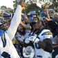 Los Angeles Chargers defensive end Melvin Ingram, left, pours candy over fans and running back Melvin Gordon during a joint NFL football practice with the Los Angeles Rams, Wednesday, Aug. 9, 2017, in Irvine, Calif. (AP Photo/Mark J. Terrill)