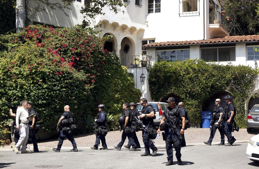 Authorities leave a home in Pacific Palisades in Los Angeles Thursday, Aug. 10, 2017. A gunman was found dead Thursday inside a huge Los Angeles home following a standoff in which he fired several rounds at the woman who lives there during a domestic argument, police said. (AP Photo/Damian Dovarganes)