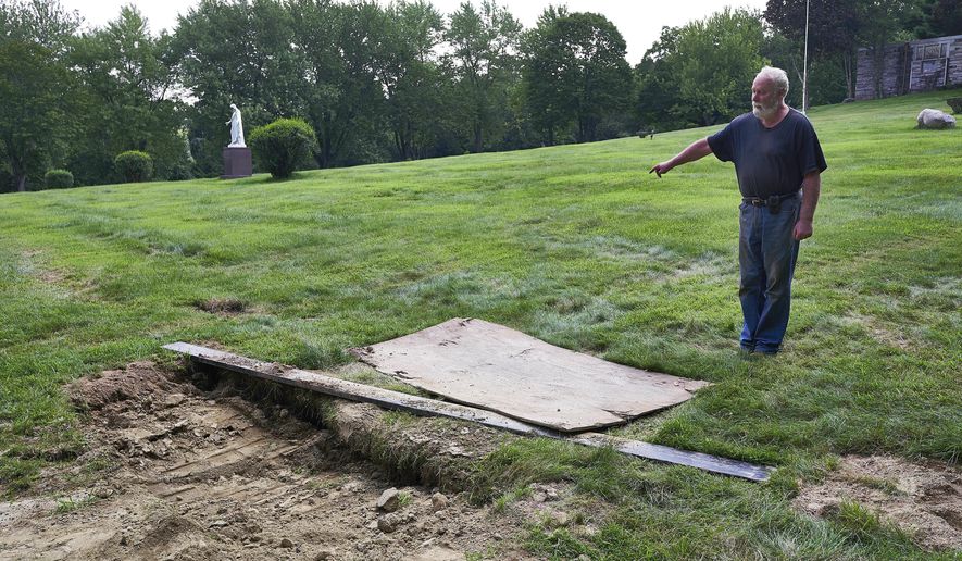 This Thursday Aug. 10, 2017 photo shows Mount Holiness Memorial Park caretaker Bill Plog as he stands by the burial plot of Cleveland Butler, in Butler, N.J. The New York Daily News reported the burial uncovered a moldering foot of a neighboring corpse that fell on top of Butler's coffin during the eulogy on Aug. 4, 2017. Plog said it's unfortunate that it happened, "but this is a graveyard." (James Keivom/The Daily News via AP)