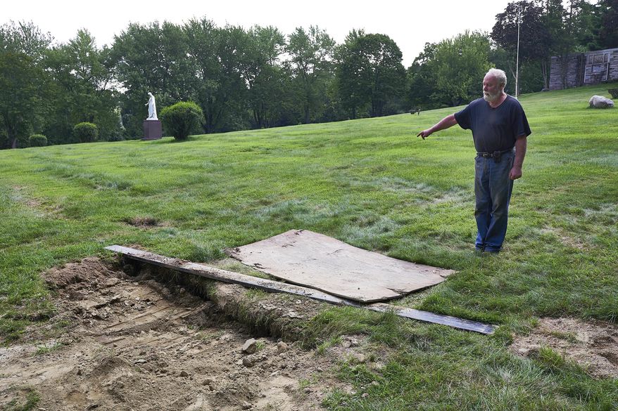 This Thursday Aug. 10, 2017 photo shows Mount Holiness Memorial Park caretaker Bill Plog as he stands by the burial plot of Cleveland Butler, in Butler, N.J. The New York Daily News reported the burial uncovered a moldering foot of a neighboring corpse that fell on top of Butler's coffin during the eulogy on Aug. 4, 2017. Plog said it's unfortunate that it happened, "but this is a graveyard." (James Keivom/The Daily News via AP)