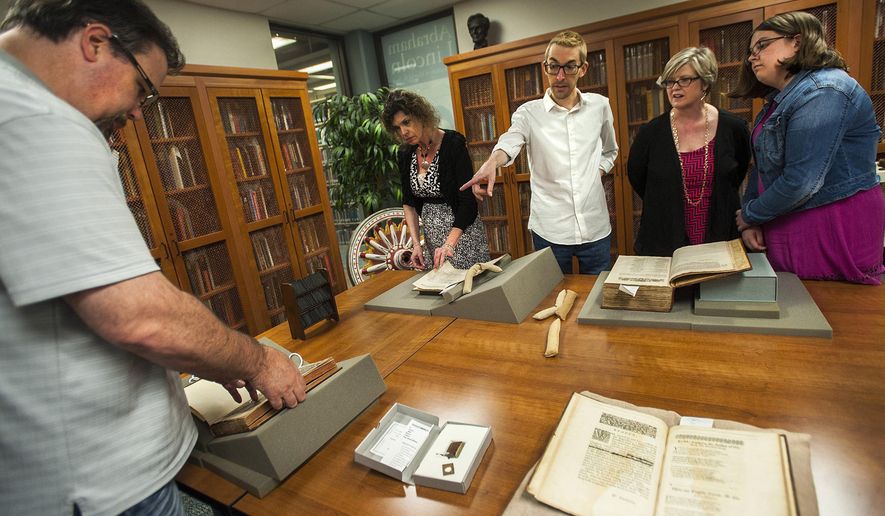 In this July 16, 2017 photo, Adam Hooks, associate professor of English from the University  of Iowa, points out several books from the time of poet and playwright William Shakespeare during Shakespearience at Illinois State University&#39;s Milner Library Special Collections room, in Normal, Ill. The room houses a handful of rare items, including books from Shakespeare&#39;s time. Those items were featured at Shakespearience along with several other rare and fine books during a program that gave visitors a rare glimpse into Shakespeare&#39;s world. (Lewis Marien/The Pantagraph via AP)