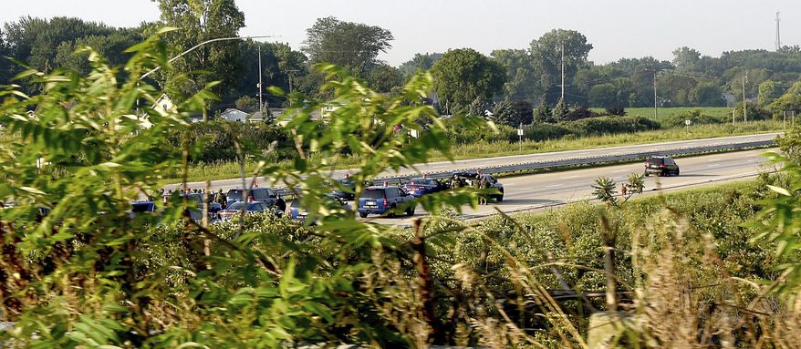 Troopers from the Michigan State Police, Monroe Post, negotiate with a man who had a gun after stopping the man on southbound Interstate 75 after he lead police on a chase that started in Pontiac and ended up on the highway in Erie Township, Mich., Thursday, Aug. 10, 2017. (Tom Hawley/The Monroe News via AP)