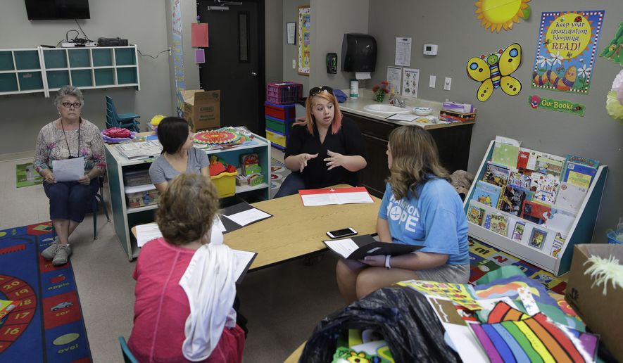 In this photo taken Aug. 8, 2017, Kelsey Nellis, second from right, instructs employees in preparation for the start of the school year at the Mountain View Christian Schools in Las Vegas. More than a third of U.S. states have created school voucher programs that bypass thorny constitutional and political issues by turning them over to non-profits that rely primarily on businesses to fund them. But the programs are raising questions about transparency and accountability at a time when supporters are urging that it be expanded into a federal program. (AP Photo/John Locher)