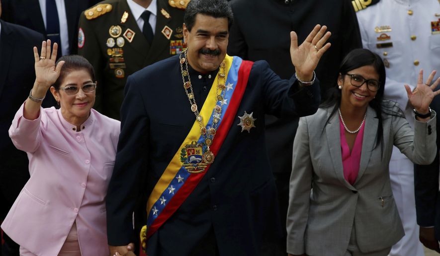 Venezuela&#x27;s President Nicolas Maduro, center, with his wife Cilia Flores, left, and Constitutional Assembly President Delcy Rodriguez wave as they arrive to the National Assembly building for a session with the Constitutional Assembly in Caracas, Venezuela, Thursday, Aug. 10, 2017. (AP Photo/Ariana Cubillos)