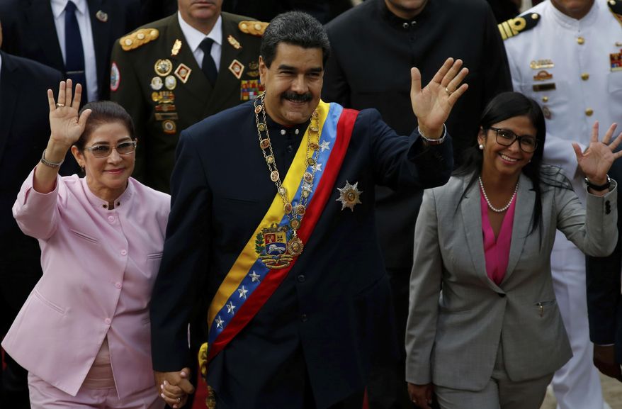 Venezuela's President Nicolas Maduro, center, with his wife Cilia Flores, left, and Constitutional Assembly President Delcy Rodriguez wave as they arrive to the National Assembly building for a session with the Constitutional Assembly in Caracas, Venezuela, Thursday, Aug. 10, 2017. (AP Photo/Ariana Cubillos)