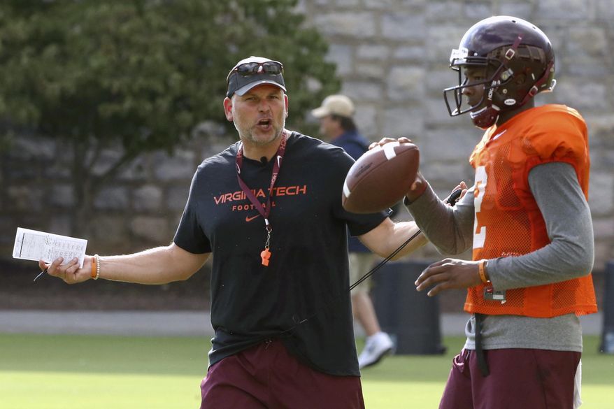 FILE - In this Thursday, Aug. 3, 2017, file photo, Virginia Tech head coach Justin Fuente instructs quarterback Hendon Hooker during NCAA college football practice in Blacksburg, Va. Fuente's second year at Virginia Tech will present some challenges similar to the first. The Hokies still have not identified a quarterback, with the options including redshirt freshman Josh Jackson, junior college transfer AJ Bush and freshman Hooker. None of them have ever taken a snap in a FBS-level game. (Matt Gentry/The Roanoke Times via AP, File)