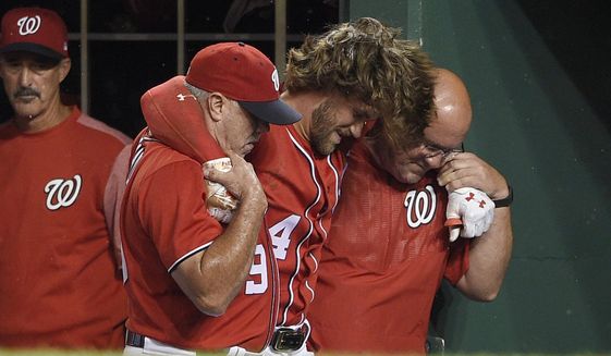 Washington Nationals&#39; Bryce Harper, center, is helped in the dugout after he was injured during the first inning of the team&#39;s baseball game against the San Francisco Giants, Saturday, Aug. 12, 2017, in Washington. (AP Photo/Nick Wass)