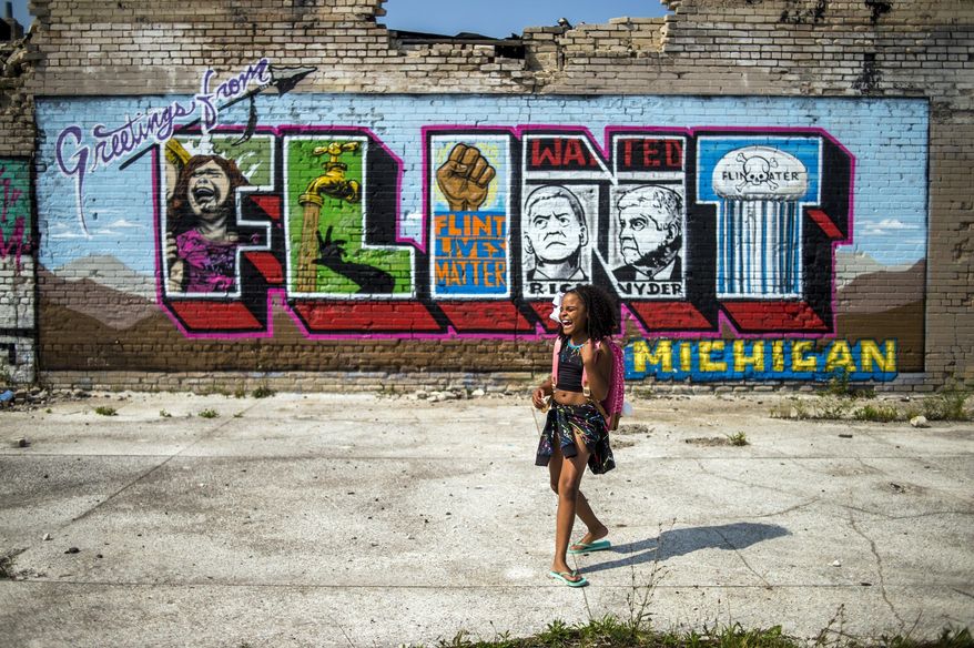 Mari Copeny, 10, known as Little Miss Flint, poses for a photo in front of a recently finished water crisis mural on Saginaw Street on Wednesday, Aug. 9, 2017, in Flint, Mich. Copeny raised more than $10,000 to give out more than 1,000 backpacks and various school supplies to Flint students. "We need to help kids in Flint that can't afford a backpack or school supplies so the people can go to school," she said. "School is important. Education is life." (Jake May/The Flint Journal-MLive.com via AP)