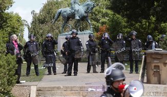 Police in riot gear guard Lee Park after a white nationalist demonstration was declared illegal and the park was cleared in Charlottesville, Va., Saturday, Aug. 12, 2017.  Hundreds of people chanted, threw punches, hurled water bottles and unleashed chemical sprays on each other Saturday after violence erupted at the white nationalist rally. (AP Photo/Steve Helber)