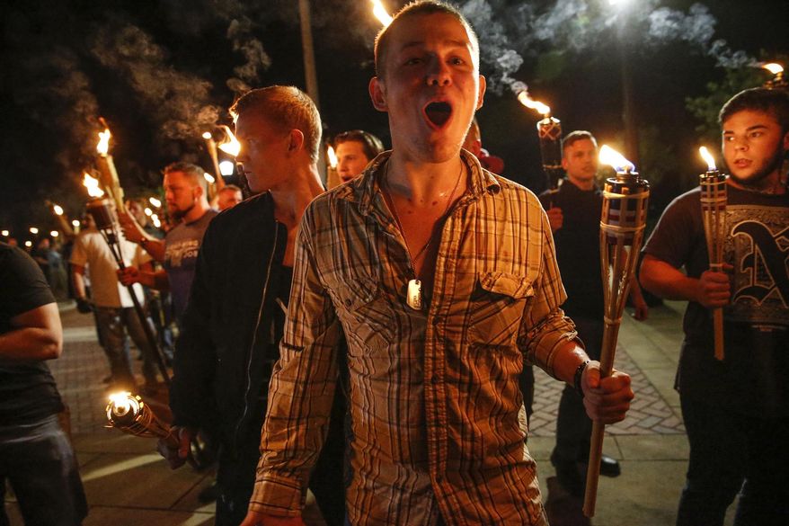 In this photo taken Friday, Aug. 11, 2017, multiple white nationalist groups march with torches through the UVA campus in Charlottesville, Va. Hundreds of people chanted, threw punches, hurled water bottles and unleashed chemical sprays on each other Saturday after violence erupted at a white nationalist rally in Virginia.  (Mykal McEldowney/The Indianapolis Star via AP) ** FILE **