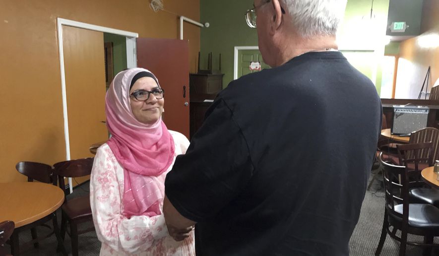 In this July 10, 2017 photo, Moina Shaiq speaks to a man after a Meet a Muslim event at Bronco Billy&#39;s Pizza Palace in Fremont, Calif. Shaiq discussed the importance of the hijab, the head scarf, and the niqab, the face covering, as well as the differences between Sunnis and Shias. She also spoke about the rights of women in Islam, and what it&#39;s like to be an American-Muslim today in her one-hour talks. (AP Photo/Kristin J. Bender)