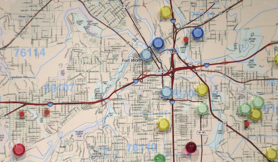 In this photo made Wednesday, May 24, 2017, colored pins on a map marks churches in areas of Fort Worth where research is predicting that there's a high risk of child abuse and neglect occurring. Aid organizations are using the research to try to focus outreach efforts into these areas. (AP Photo/LM Otero)