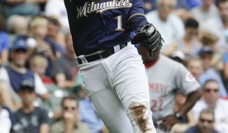 Milwaukee Brewers&#39; Neil Walker makes a play on a ball hit by Cincinnati Reds&#39; Scooter Gennett during the second inning of a baseball game Sunday, Aug. 13, 2017, in Milwaukee. (AP Photo/Morry Gash)