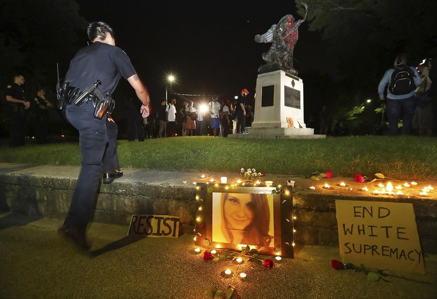 Police move in to Piedmont Park to prevent protesters from toppling a Confederate monument with a chain after they spray-painted it, Sunday, Aug. 13, 2017, in Atlanta. The peace monument at the 14th Street entrance depicts a angel of peace stilling the hand of a Confederate soldier about to fire his rifle. Protesters decrying hatred and racism converged around the country on Sunday, saying they felt compelled to counteract the white supremacist rally that spiraled into deadly violence in Virginia. (Curtis Compton/Atlanta Journal-Constitution via AP)