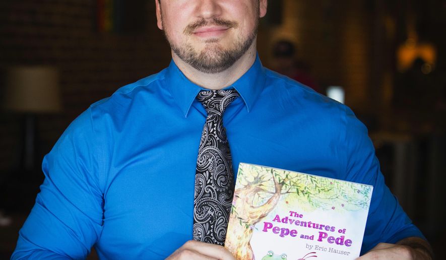 In this Thursday, Aug. 10, 2017 photo, Rodriguez Middle School assistant principal Eric Hauser poses his book "The Adventures of Pepe and Pede" in Denton, Texas. Hauser has removed an assistant principal from his post after he authored a children's book whose central character is also a white nationalist symbol. Pepe the Frog appeared more than a decade ago in an online cartoon and the Anti-Defamation League says the character has been appropriated by white supremacists and other racists in online memes. (Tailyr Irvine/The Dallas Morning News via AP)
