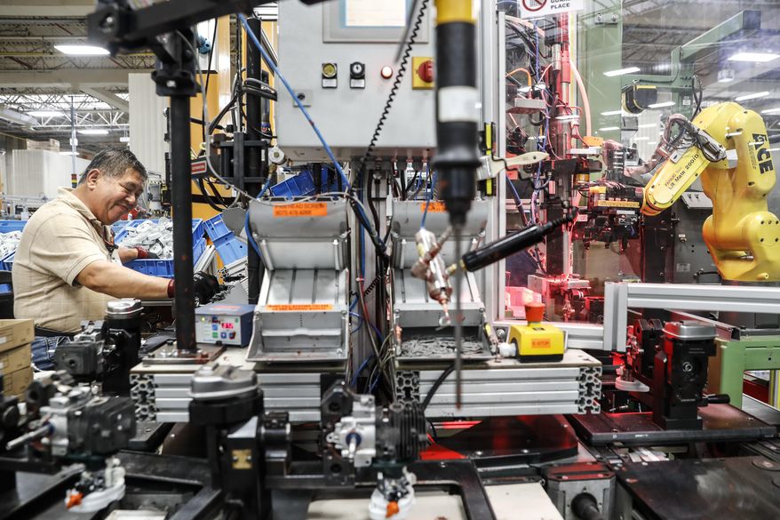 In this Thursday, May 25, 2017 photo, an assembly line laborer works across from a collaborative robot, right, at the Stihl Inc. manufacturing facility in Virginia Beach, Va. At the plant human workers are interspersed with computers and robotics that require trained technicians to service and maintain while reducing the company&#39;s need for pursuing traditional manual laborers. (AP Photo/John Minchillo)