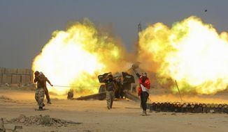 FILE - in this Sunday, May 29, 2016 file photo, Iraqi security forces and allied Popular Mobilization forces fire artillery during fight against Islamic State militants in Fallujah, Iraq. Iraq&#39;s mostly Shiite militia forces say they will participate in the next major battle against IS in Iraq after victory was declared in Mosul last month. (AP Photo/Anmar Khalil, File)