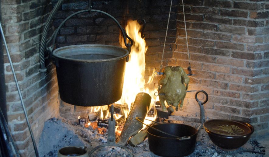In this June 10, 2017 photo provided by Tracee Herbaugh, mustard greens cook in a cast iron pot hanging over a fire at Old Sturbridge Village in Sturbridge, Mass. In the 19th century, most meals had to be cooked over the home's central hearth. (Tracee Herbaugh via AP)
