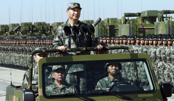 In this file photo taken Sunday, July 30, 2017, and released by Xinhua News Agency, Chinese President Xi Jinping stands on a military jeep as he inspects troops of the People&#x27;s Liberation Army during a military parade to commemorate the 90th anniversary of the founding of the PLA at Zhurihe training base in north China&#x27;s Inner Mongolia Autonomous Region. (Li Gang/Xinhua via AP) ** FILE **