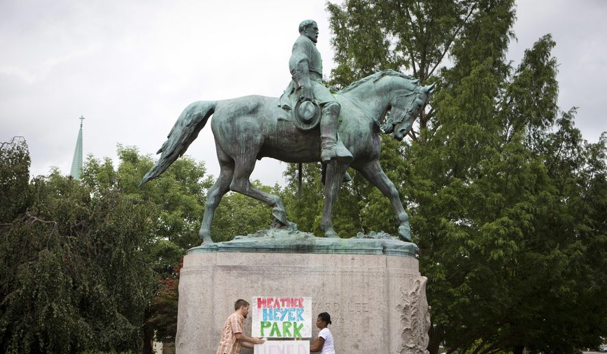 Tom Lever, 28, and Aaliyah Jones, 38, both of Charlottesville, put up a sign that says &amp;quot;Heather Heyer Park&amp;quot; at the base of the Confederate general Robert E. Lee monument in Emancipation Park Tuesday, Aug. 15 in Charlottesville, Va.  Alex Fields Jr., is charged with second-degree murder and other counts after authorities say he rammed his car into a crowd of counterprotesters, including Heyer, Saturday, where a white supremacist rally took place.  (AP Photo/Julia Rendleman)