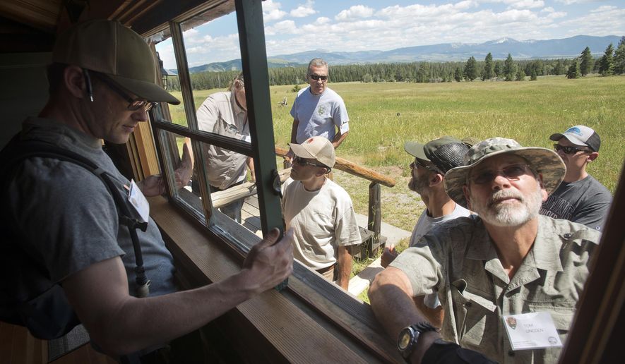 This photo taken July 12, 2017, shows Kevin Brothers, left, and Tom Lincoln removing a window from one of the guest cabins at the White Grass Dude Ranch in Grand Teton National Park as part of a window and door restoration workshop. The ranch has become the headquarters for the Western Center for Historic Preservation, where participants come from national parks around the country and learn restoration and preservation skills to take back to their respective park or monument. (Bradly J. Boner /Jackson Hole News & Guide via AP)