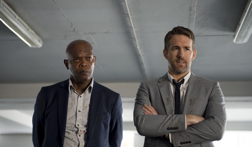 This image released by Lionsgate shows Samuel L. Jackson, left, and Ryan Reynolds in "The Hitman's Bodyguard." (Jack English/Lionsgate via AP)