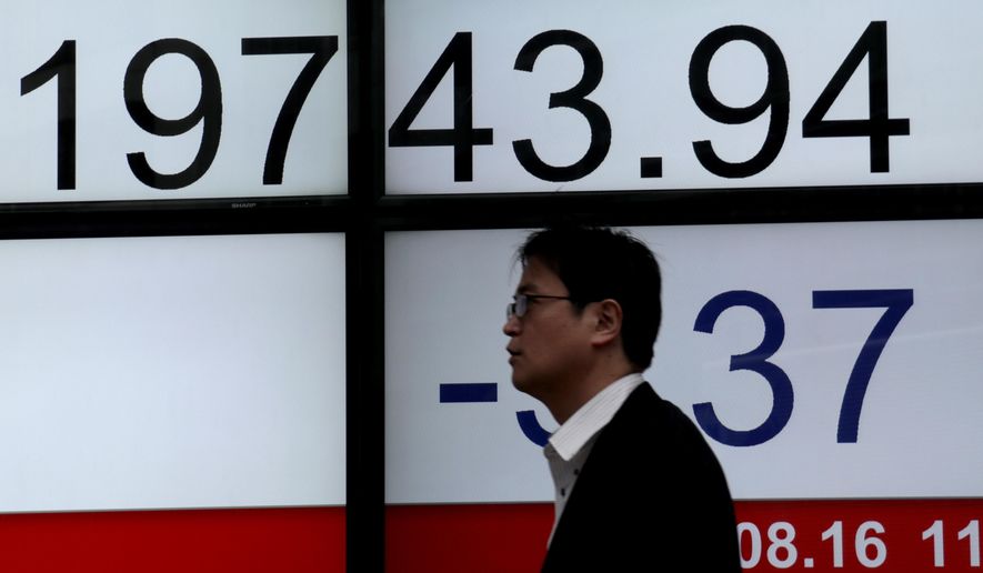 A man walks past an electronic stock indicator of a securities firm in Tokyo, Wednesday, Aug. 16, 2017. Asian stock markets were mixed Wednesday after U.S. indexes took small losses as Washington and North Korea indicated their willingness to reduce nuclear tensions.(AP Photo/Shizuo Kambayashi)