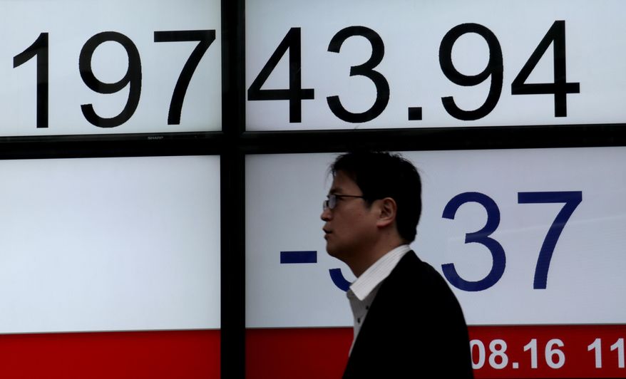 A man walks past an electronic stock indicator of a securities firm in Tokyo, Wednesday, Aug. 16, 2017. Asian stock markets were mixed Wednesday after U.S. indexes took small losses as Washington and North Korea indicated their willingness to reduce nuclear tensions.(AP Photo/Shizuo Kambayashi)