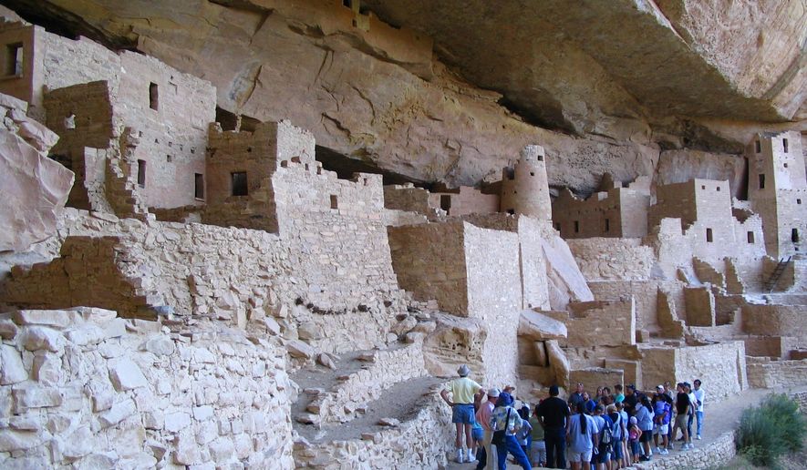 FILE - In this Aug. 27, 2005 file photo, visitors tour Cliff Palace, an ancient cliff dwelling in Mesa Verde National Park, Colo. Researchers say they have new evidence that ancestral Pueblo people who disappeared from the Mesa Verde cliff dwellings of southwestern Colorado 700 years ago migrated to what is now New Mexico. DNA from the bones of domesticated turkeys. The turkey DNA shows Native American people in the Rio Grande Valley of northern New Mexico raised and ate the same genetic strain of bird as the Mesa Verde people, and that the turkeys arrived in New Mexico about the same time Mesa Verde was abandoned, the researchers said. (AP Photo/Beth J. Harpaz,File)