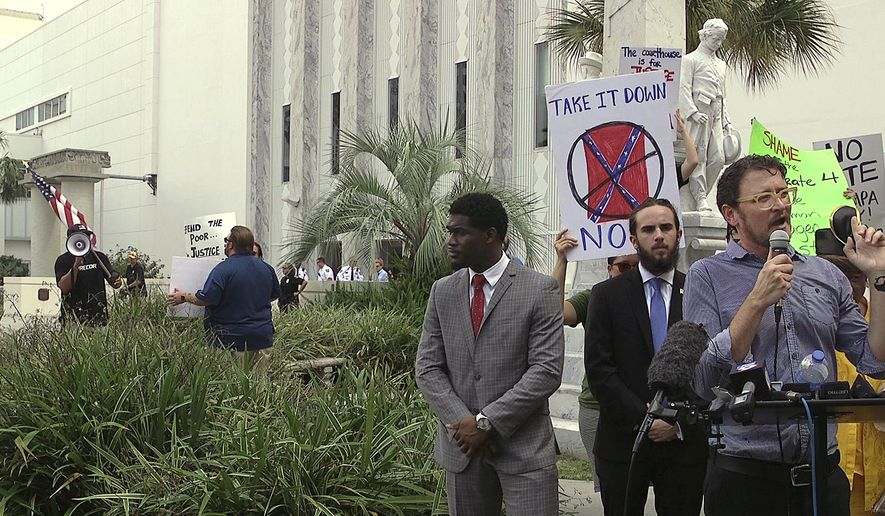 Tampa For Justice member Kelly Benjamin, right, leads a news conference in front of the Confederate memorial while protester Gary Snow, left, uses a bull horn to try and disrupt the event in Tampa, Fla., Thursday, Aug. 17, 2017. (James Borchuck/Tampa Bay Times via AP)