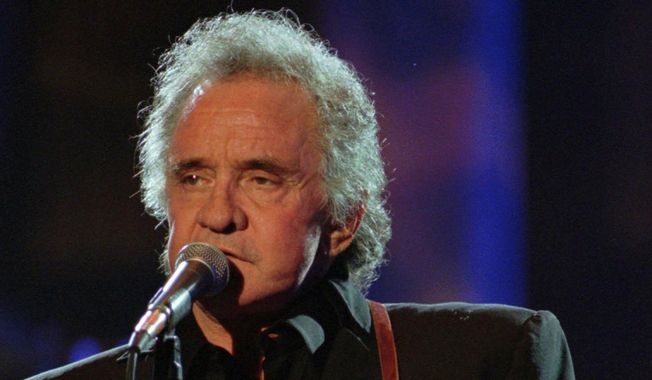 FILE - In this Sept. 2, 1995 file photo, Johnny Cash performs during his segment of the Concert for the Rock and Roll Hall of Fame in Cleveland.   In a lengthy Facebook post from John Carter Cash on Wednesday, Aug. 16, 2017, the siblings say they were “sickened” when they were alerted to a video of a self-proclaimed neo-Nazi wearing a T-shirt with their father’s name at a white nationalist rally in Charlottesville, Va., that erupted into deadly violence.The post, says Johnny Cash’s heart “beat with the rhythm of love and social justice.” They requested his name “be kept far away from destructive and hateful ideology.” (AP Photo/Mark Duncan)