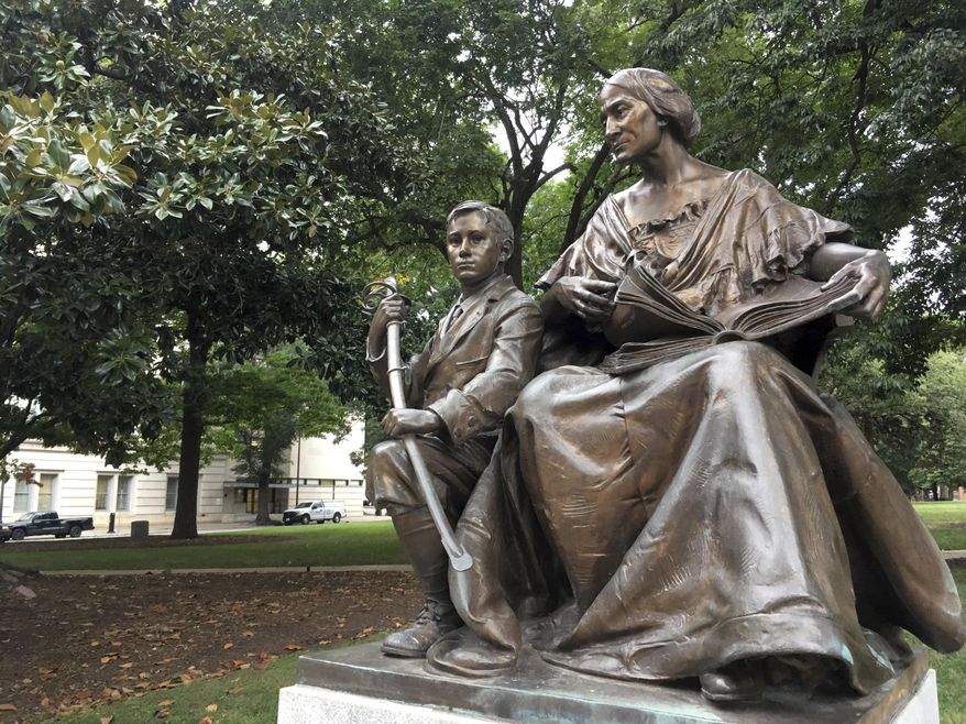 A monument inscribed "To the North Carolina Women of the Confederacy" is seen on Thursday, Aug. 17, 2017 on the grounds of the old State Capitol in Raleigh, N.C. The 7-foot-tall monument of a woman and young boy is made of bronze and granite, and it was dedicated in 1914. (AP Photo/Jonathan Drew)