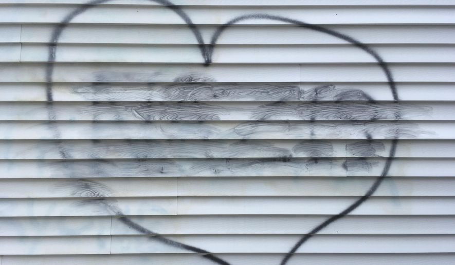 The word "NAZIS", smudged from a cleaning attempt, appears in the center of a heart symbol on the wall of a building, which houses the New Hampshire Republican Party, in Concord, N.H., Thursday Aug. 17, 2017. A party advisor is blaming "malcontents" for the vandalism. (AP Photo/Mike Casey)