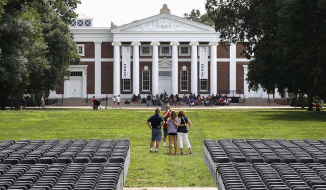 A family takes photographs during first year move-in day while on the Lawn of the University of Virginia, Friday, Aug. 18, 2017, in Charlottesville, Va., a week after a white nationalist rally took place on there. (AP Photo/Jacquelyn Martin)